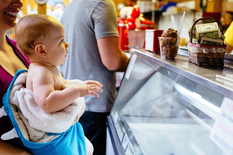 Baby watches all around him at a ice cream shop
