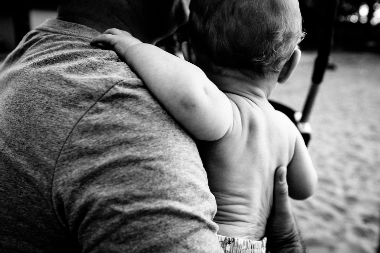Black and white. Father carrying baby boy
