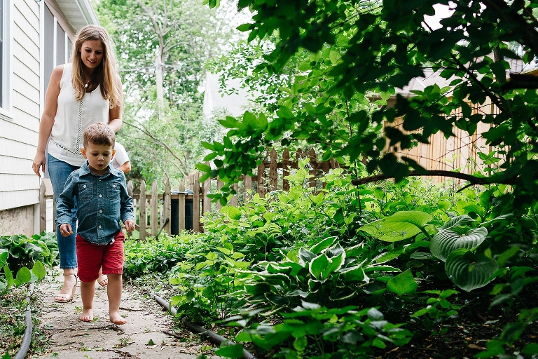 Mother walks down path next to her house behind her son.