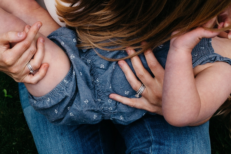 Mother cradles young girl in her arms.
