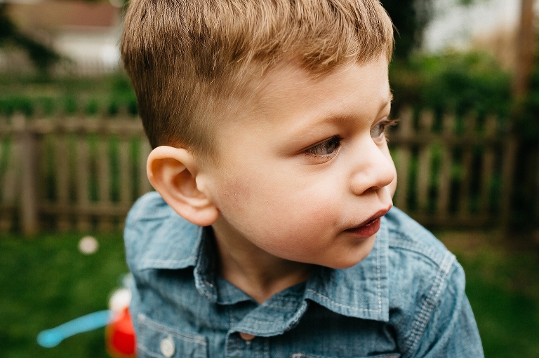 Young boys face as he plays outside in backyard.
