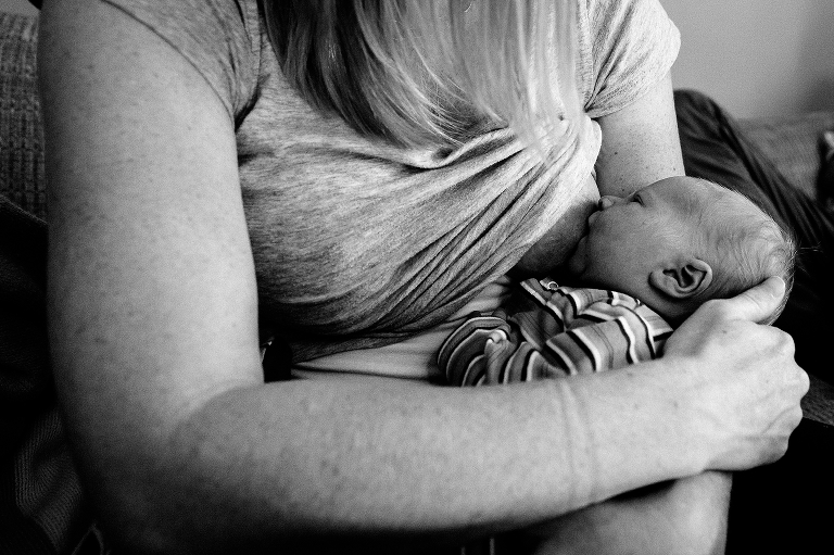 Black and white. Mother holds breastfeeding newborn baby