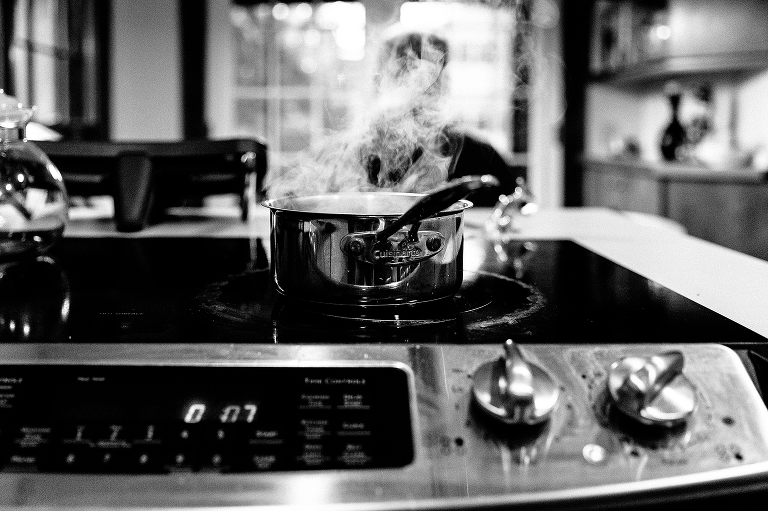 Black and white, stove with kitchen pot boiling water visible steam 