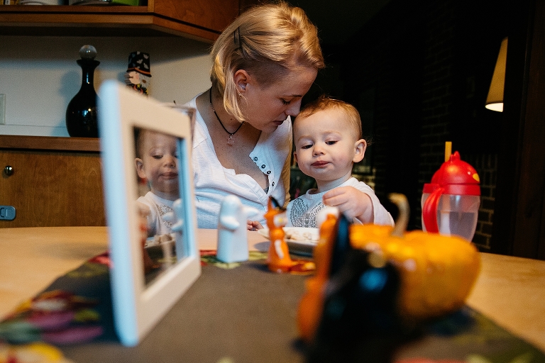 Mother and daughter sit at dinner table eating food