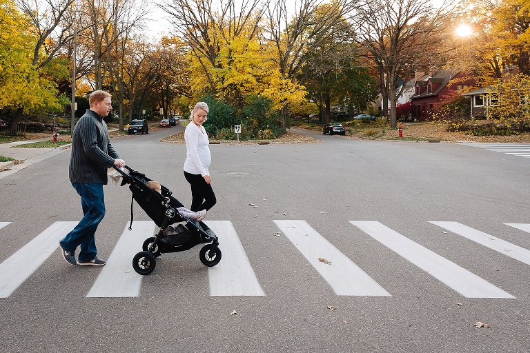 Family walks across street with father pushing baby in stroller