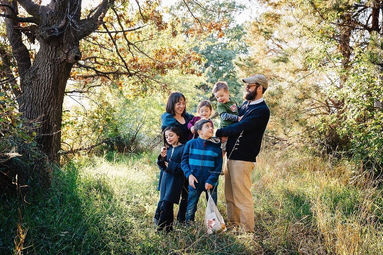 Mother, Father, and their four children stand outside in a grassy path.