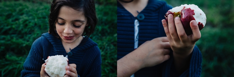 Young girl eats red apple while at a apple orchard.