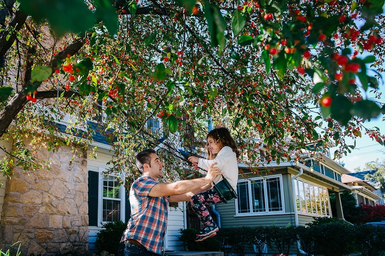 dad pushes daughter in a tree swing that is in a cherry tree. Outside Family Photography Activity Ideas