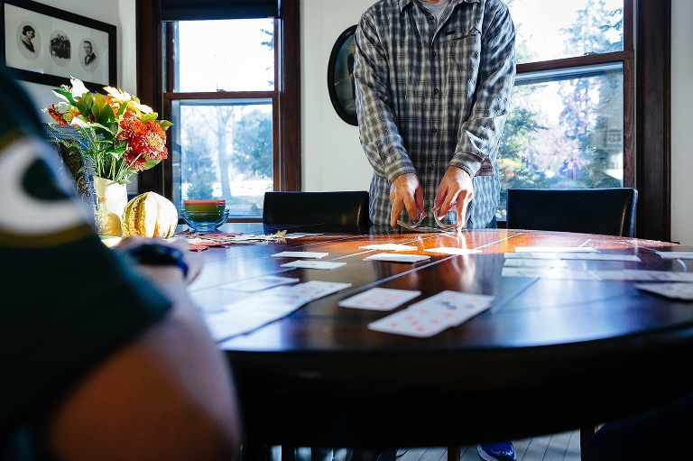 Man shuffles deck of cards on table
