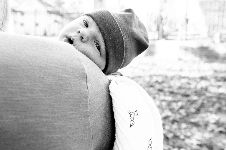 Black and white. Newborn baby lays outside in bed looking around him
