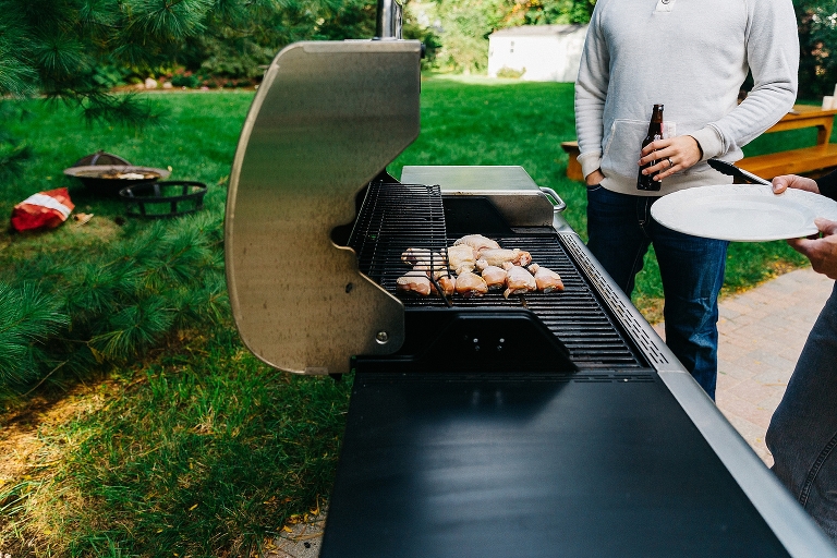 Father and son cook chicken on the grill together