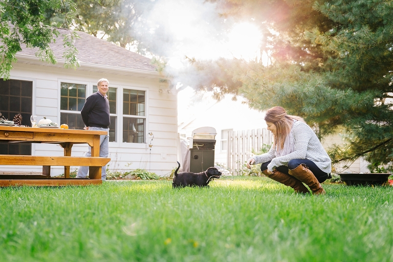 Family plays outside black lab puppy