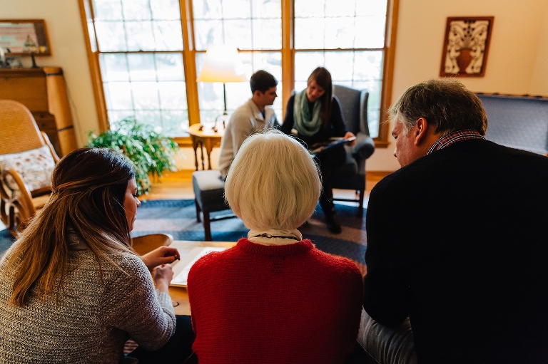 Family sits in the living room looking at old picture books