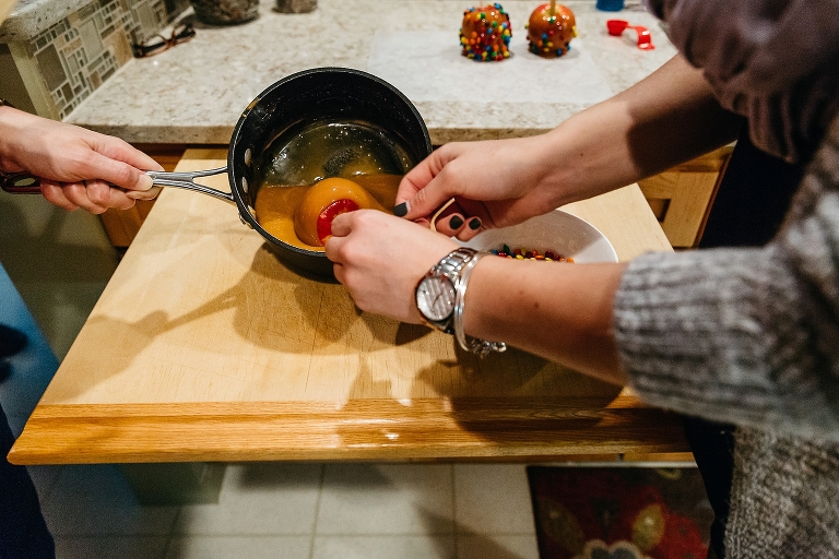 Family dips apple into pan of caramel