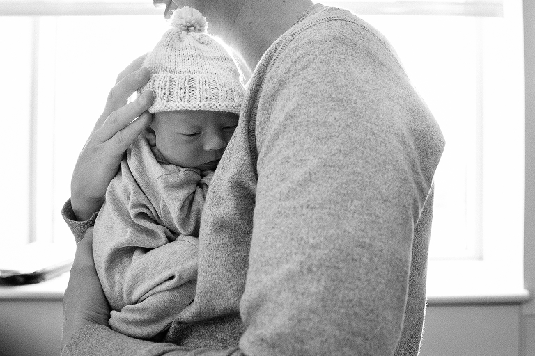 Black and white, Father holds newborn baby son in hospital