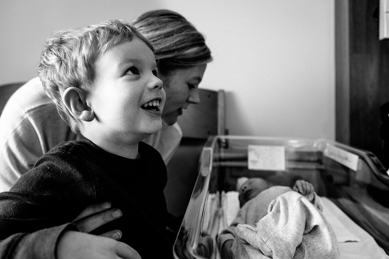 Black and white, Mother and son watch newborn baby brother sleep in hospital