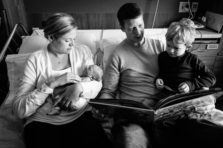 Black and white, Family reads picture book with newborn baby in hospital