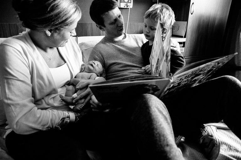 Black and white. Family spends time with newborn baby in hospital.