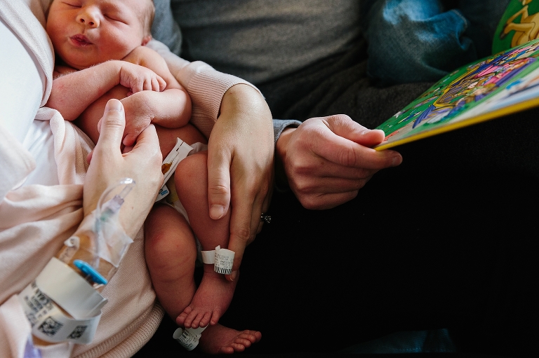 Sleeping newborn baby holds mothers hand in hospital.