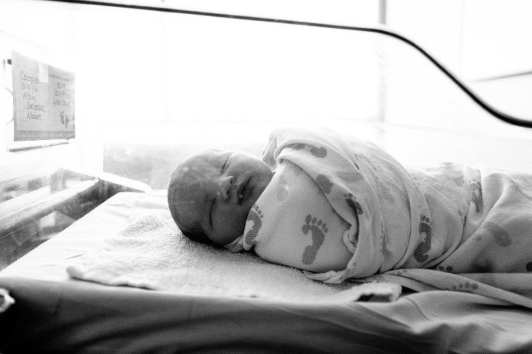 Black and white. Newborn baby boy sleeps in hospital bed