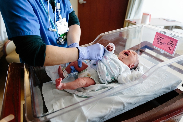Nurse changes newborn baby in hospital