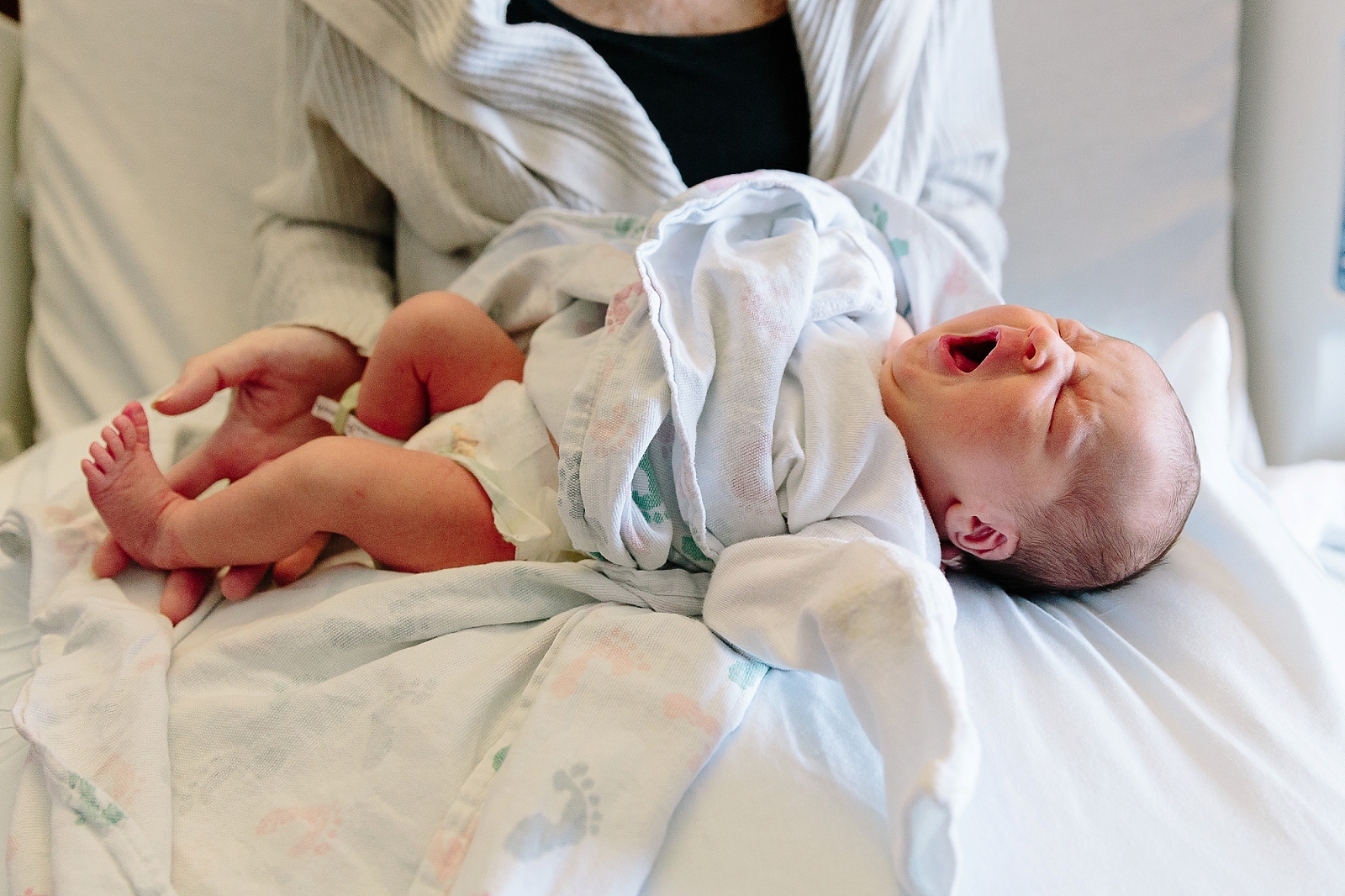Newborn baby stretches and yawns in hospital