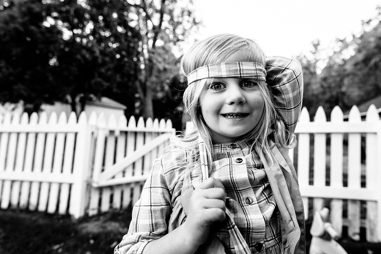 Black and white. girl outside wears dress belt as bandana on her head