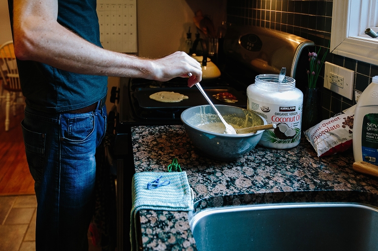 Man dips ladle in bowl of pancake batter for Sunday morning pancakes