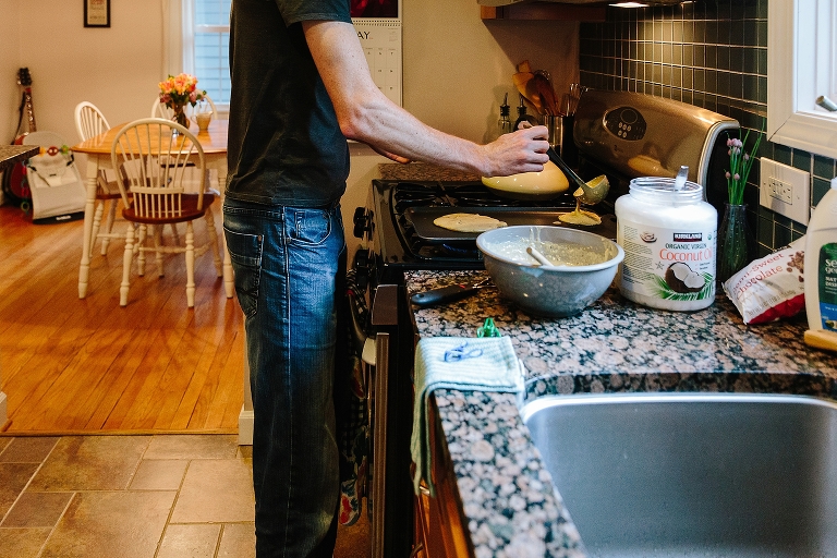 Man ladles pancake batter on griddle during a Sunday morning pancakes photo session