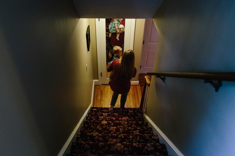 Mom holds baby walking down the stairs 