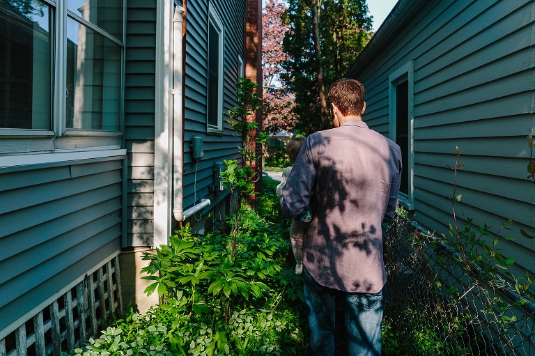spring foliage leaves a shadow on dad's back walking in backyard during a Sunday morning pancakes photo session