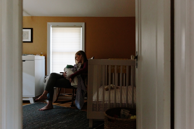 Mom rocks and nurses baby in nursery before a nap in a Sunday morning pancakes photo session