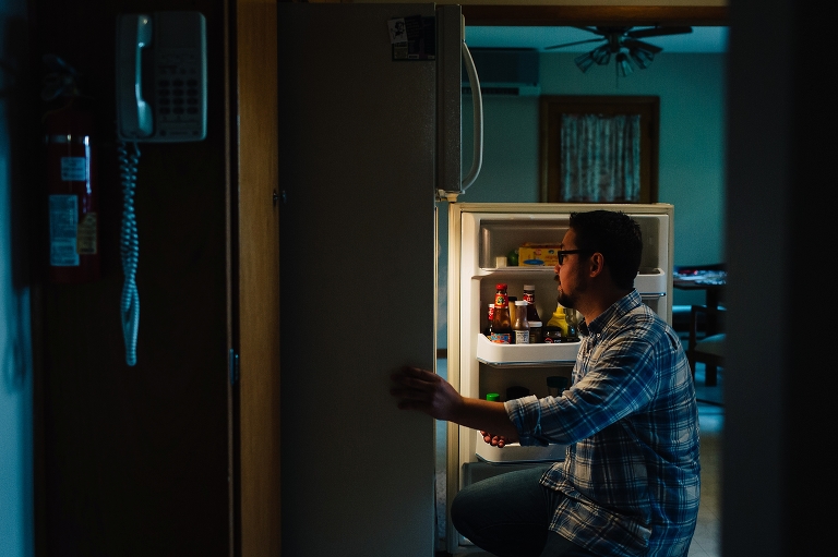 Man looks in fridge in the kitchen.