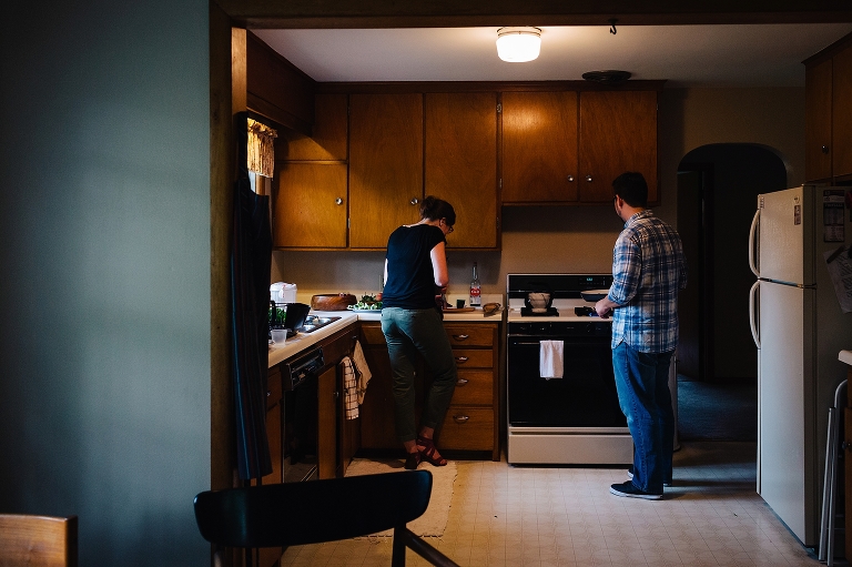 Couple cooks dinner together in kitchen.
