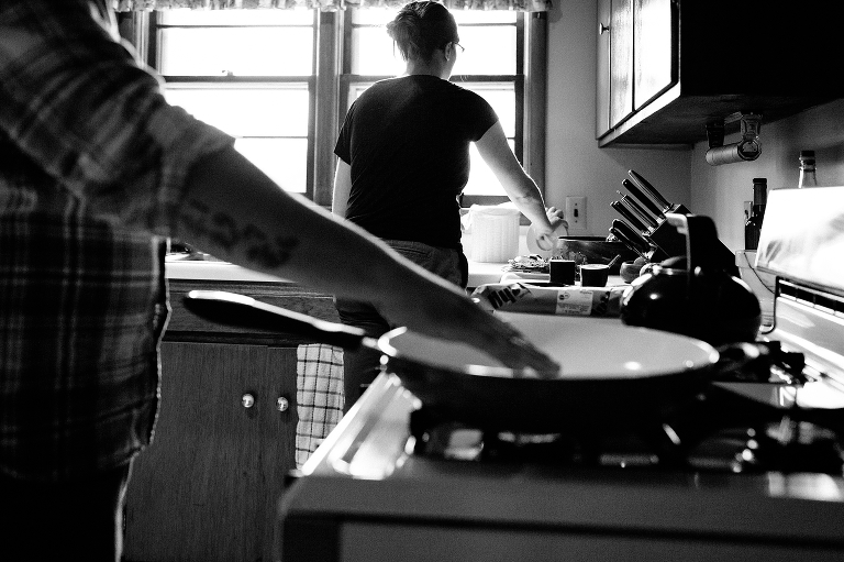 Black and white. Man and woman cooking dinner together in kitchen
