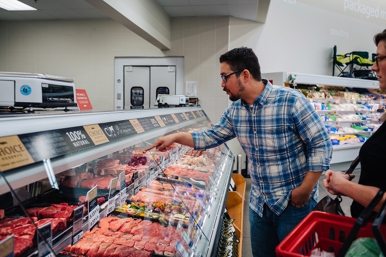 Man in grocery store points at meat counter