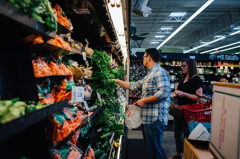 A couple grocery shopping for produce.