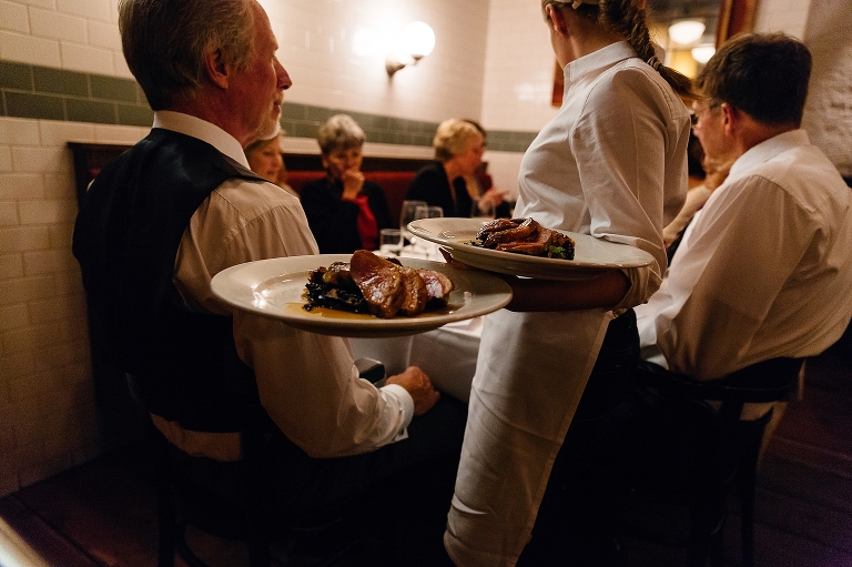 waiter serving dinner entrees