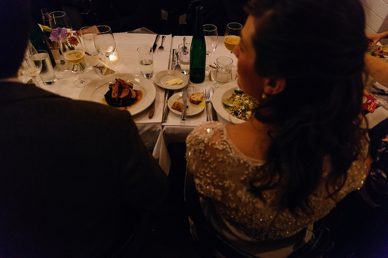 Bride and groom sit with their entrees at restaurant after wedding
