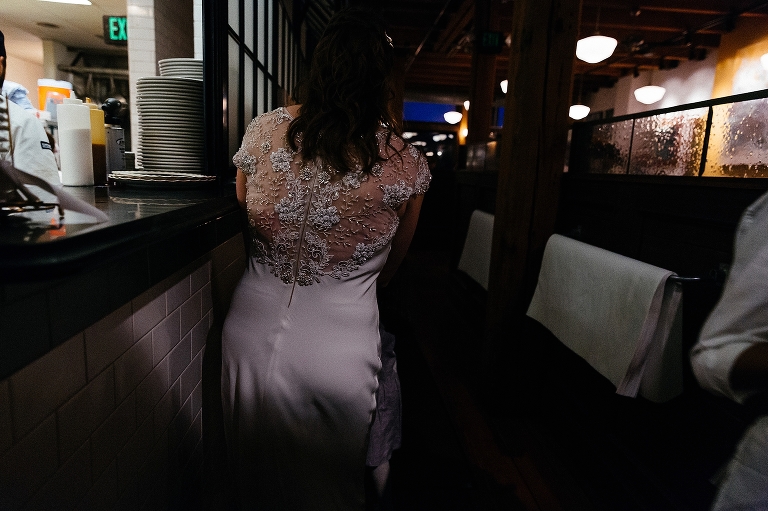 Bride wearing wedding dress walks through restaurant