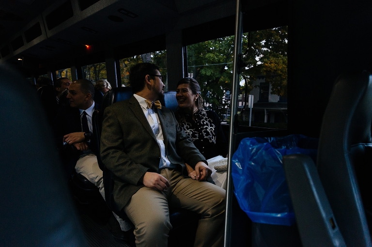 Bride and groom ride on a bus with family after the wedding