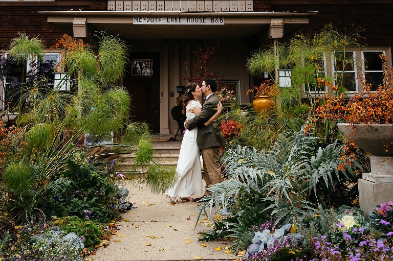 Bride and groom kiss outside wedding venue after getting married