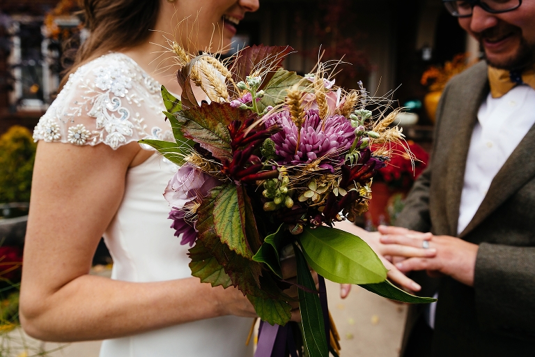 Bride holding bouquet shows groom wedding ring
