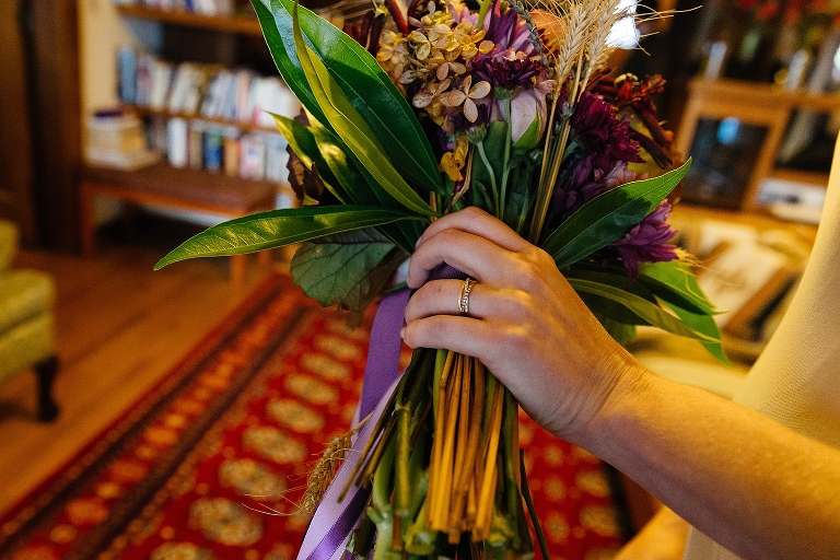 Bride holds bouquet wearing new wedding ring