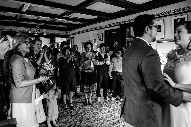 Black and white. Family and friends clap at wedding for the newly weds.