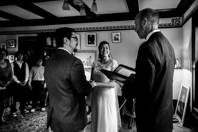 Black and white. Bride and groom smile at wedding ceremony