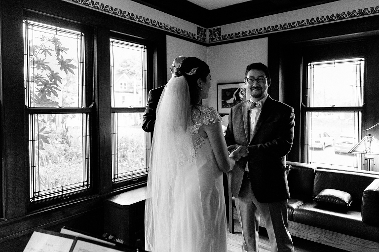 Black and white, Bride and groom hold hands at their wedding ceremony.