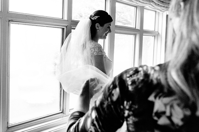 Black and white, Bride wearing wedding dress and vail gets reading to walk down the aisle