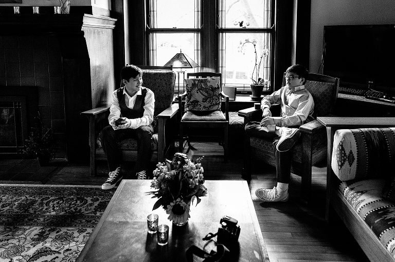 Black and white. Two young boys sit together waiting for the wedding
