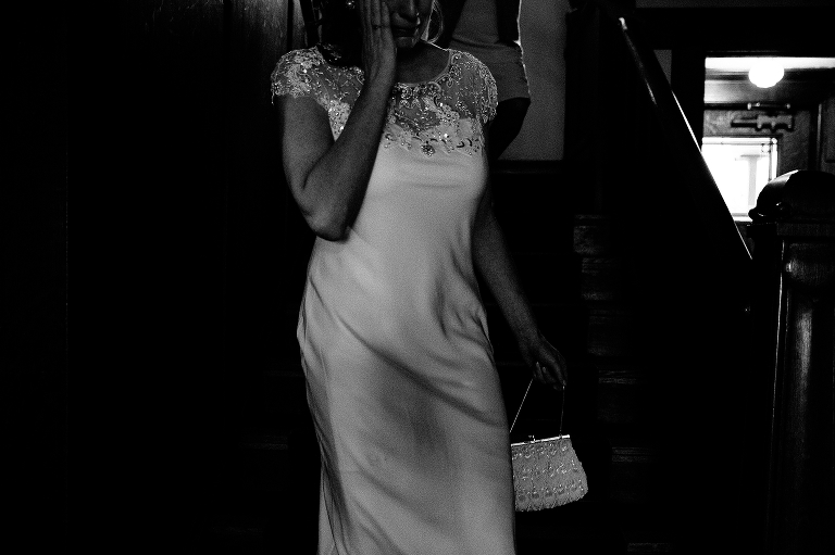 Black and white. Bride dressed and ready for her wedding walks down stairs
